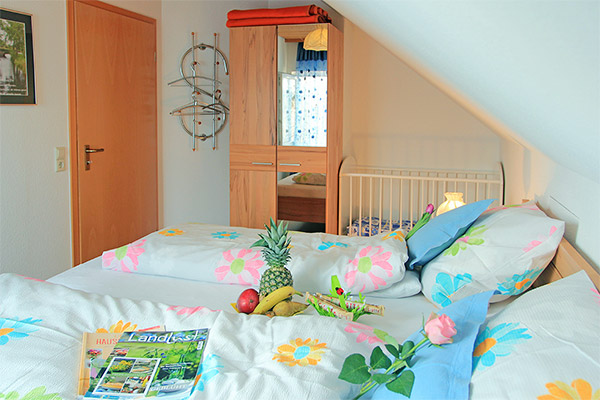 Schlafzimmer mit Doppelbett und Babybett