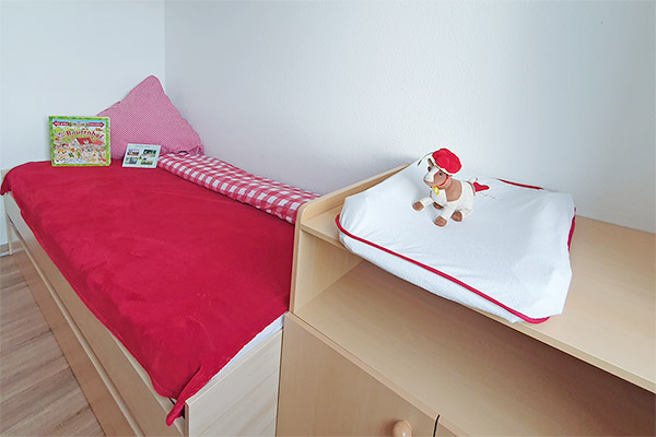 Schlafzimmer mit Kinderbett und Wickeltisch